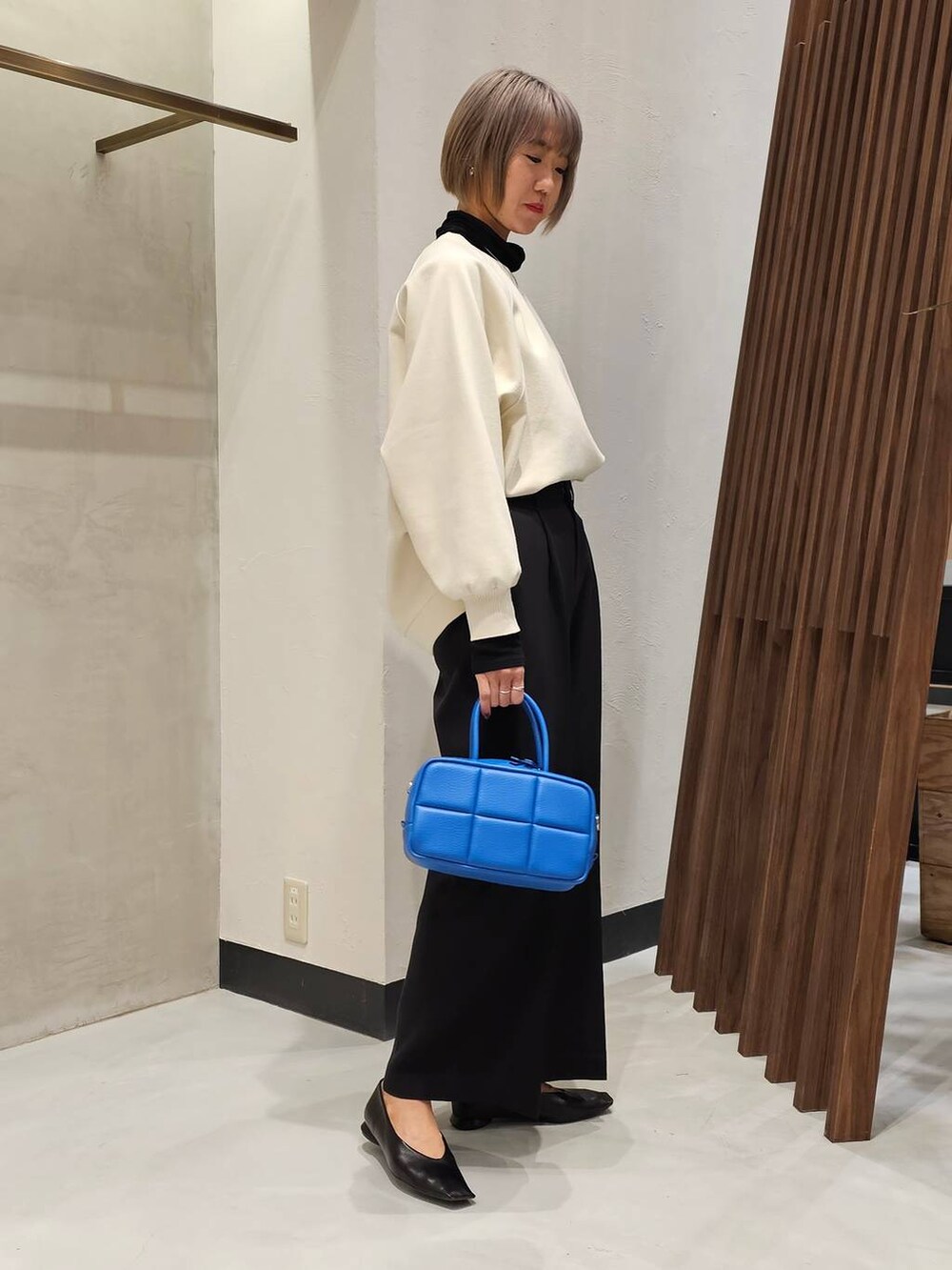 ブラック系のパンプス、ブラック系のTシャツ/カットソー、ホワイト系のニット/セーターを着用したレディースの冬コーディネートの2枚目の写真