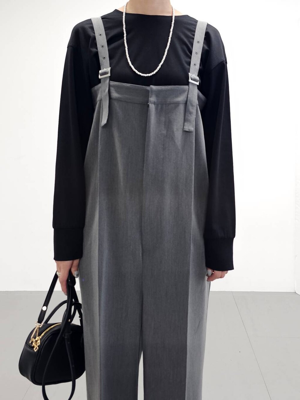 グレー系のサロペット/オーバーオール、その他のサンダル、ブラック系のTシャツ/カットソーを着用したレディースの秋コーディネートの2枚目の写真