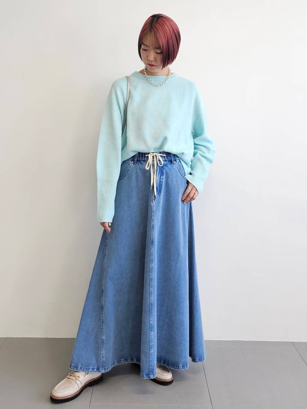 ベージュ系のローファー、ブルー系のニット/セーター、ブルー系のスカートを着用したレディースの冬コーディネートの4枚目の写真