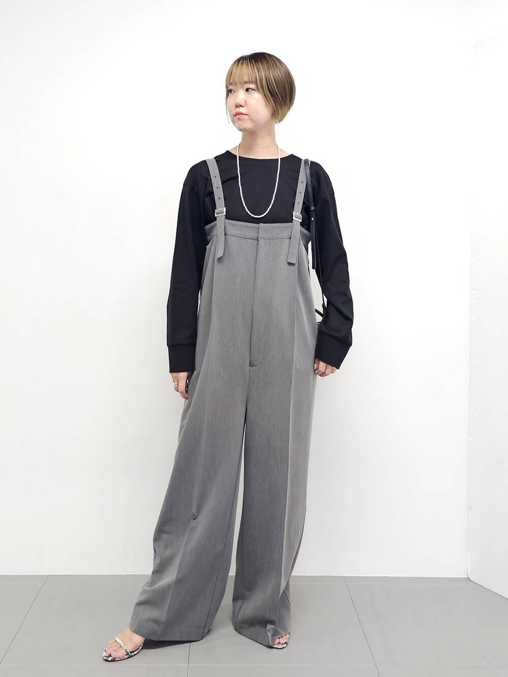 グレー系のサロペット/オーバーオール、その他のサンダル、ブラック系のTシャツ/カットソーを着用したレディースの秋コーディネートの7枚目の写真