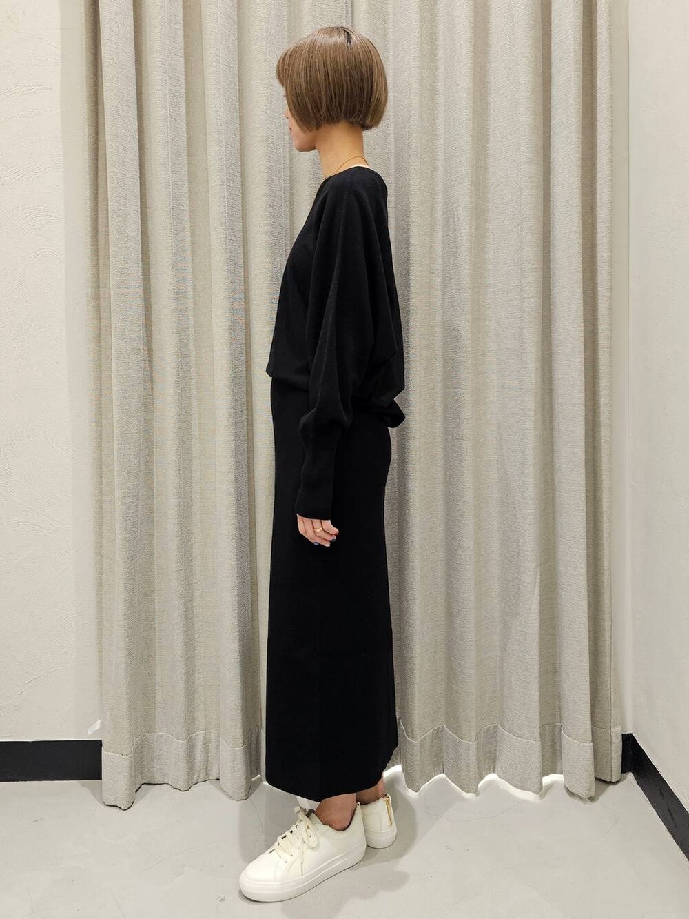 ブラック系のTシャツ/カットソー、ブラック系のスカート、ホワイト系のスニーカーを着用したレディースの冬コーディネートの3枚目の写真