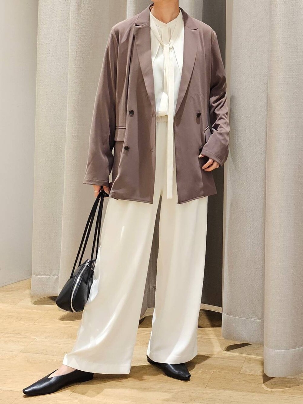 ホワイト系のスラックス、ホワイト系のシャツ/ブラウス、グリーン系のテーラードジャケットを着用したレディースの冬コーディネートの2枚目の写真