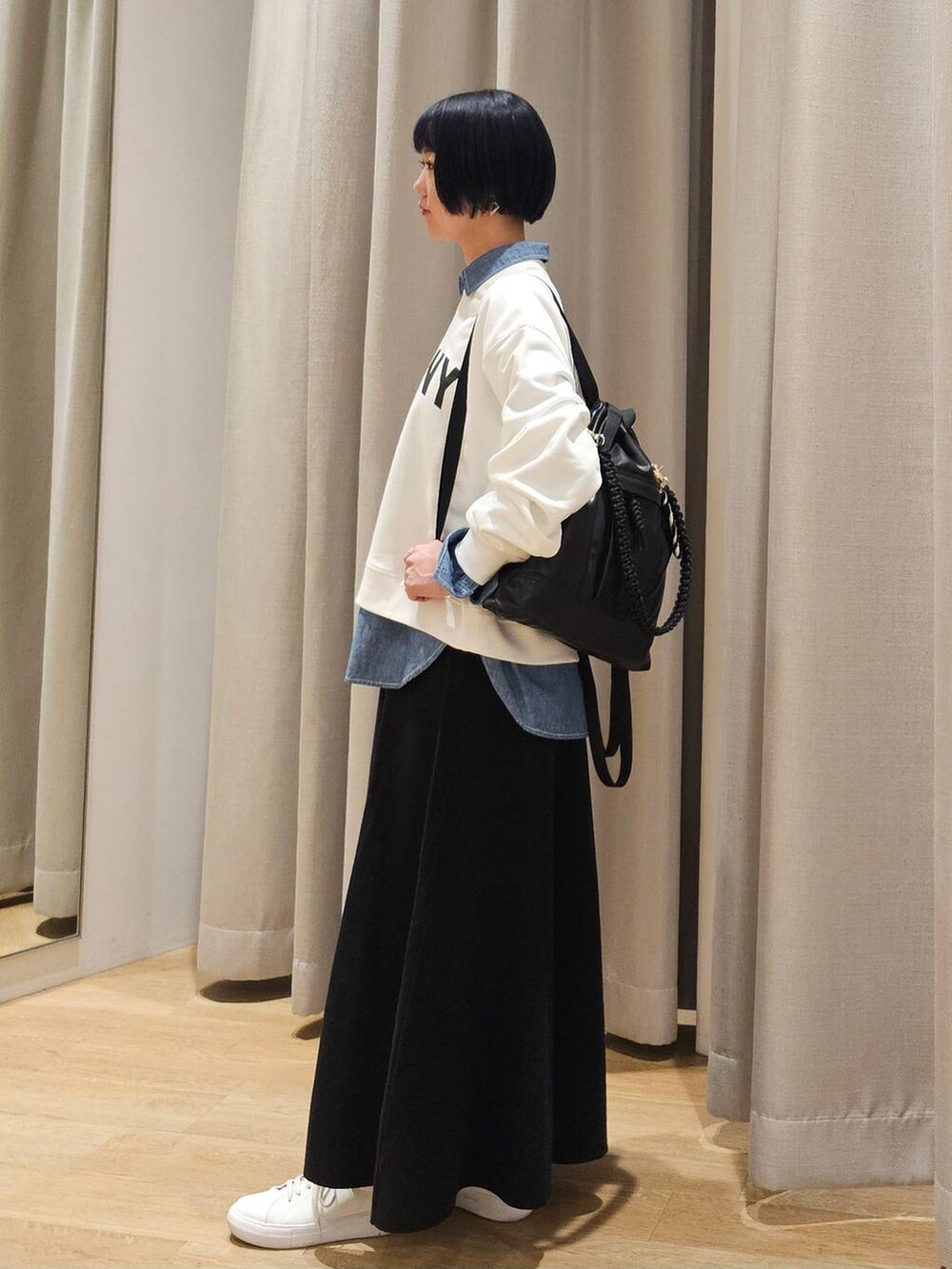ブラック系のバックパック/リュック、ブラック系のスカート、ホワイト系のスウェットを着用したレディースの冬コーディネートの3枚目の写真