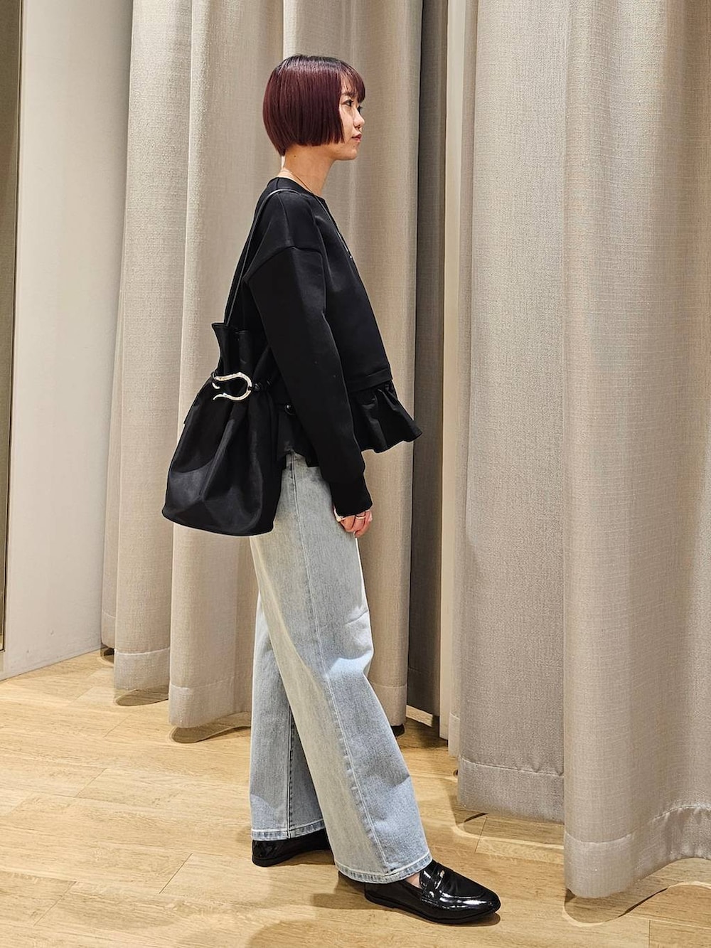 ブルー系のデニムパンツ、ブラック系のTシャツ/カットソー、ブラック系のトートバッグを着用したレディースの冬コーディネートの7枚目の写真