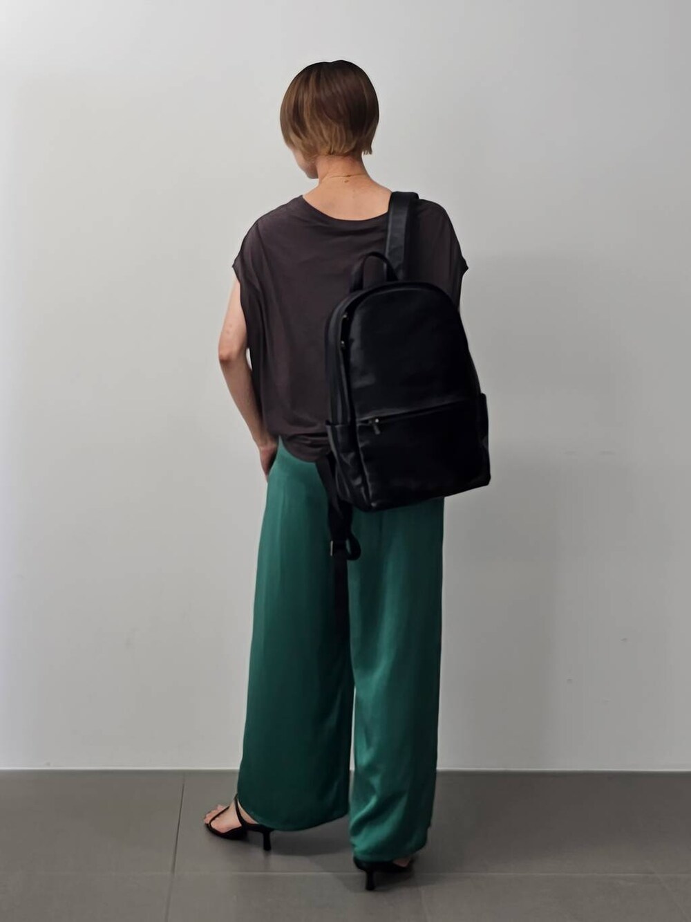 ブラック系のサンダル、グリーン系のその他パンツ、ブラック系のバックパック/リュックを着用したレディースの夏コーディネートの5枚目の写真