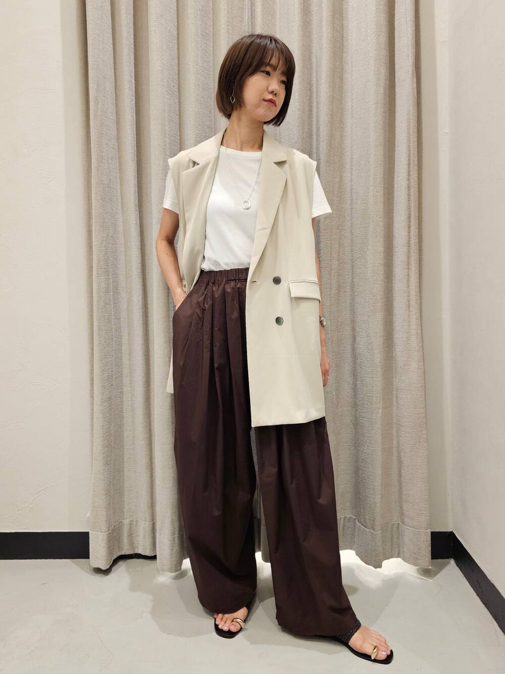 ブラウン系のその他パンツ、ホワイト系のTシャツ/カットソー、ブラック系のサンダルを着用したレディースの夏コーディネートの5枚目の写真