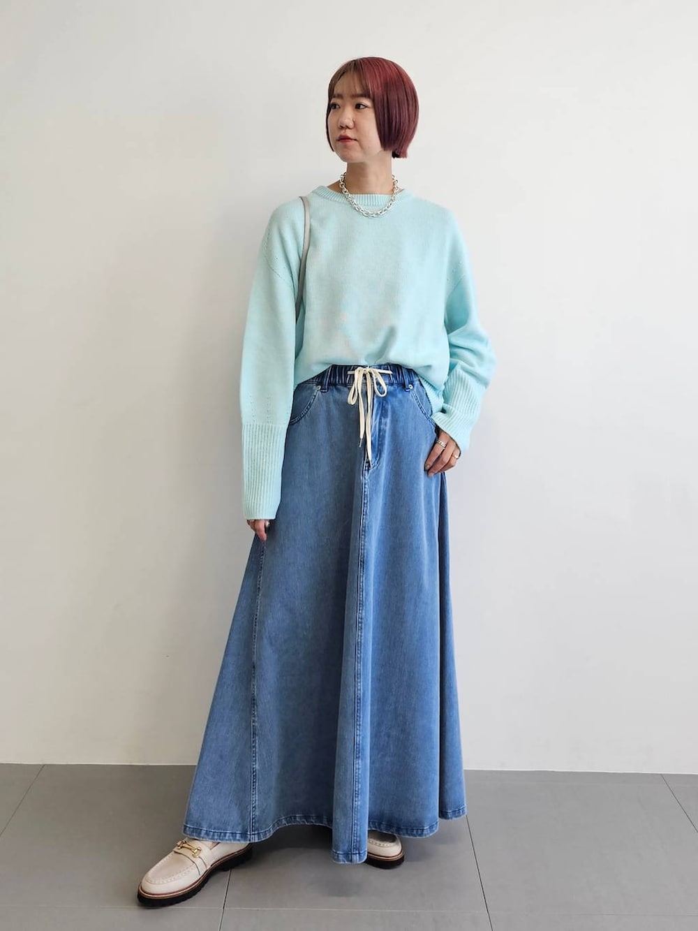 ベージュ系のローファー、ブルー系のニット/セーター、ブルー系のスカートを着用したレディースの冬コーディネートの2枚目の写真