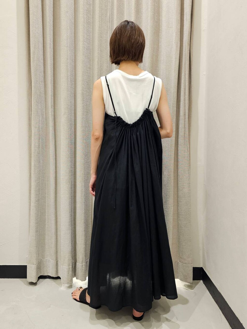 ブラック系のサンダル、ブラック系のワンピース、ホワイト系のTシャツ/カットソーを着用したレディースの夏コーディネートの4枚目の写真