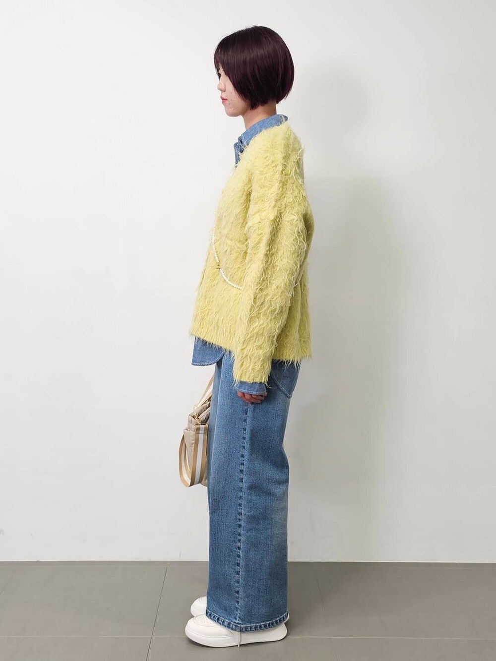 ブルー系のデニムパンツ、ブルー系のシャツ/ブラウス、イエロー系のカーディガン/ボレロを着用したレディースの秋コーディネートの2枚目の写真