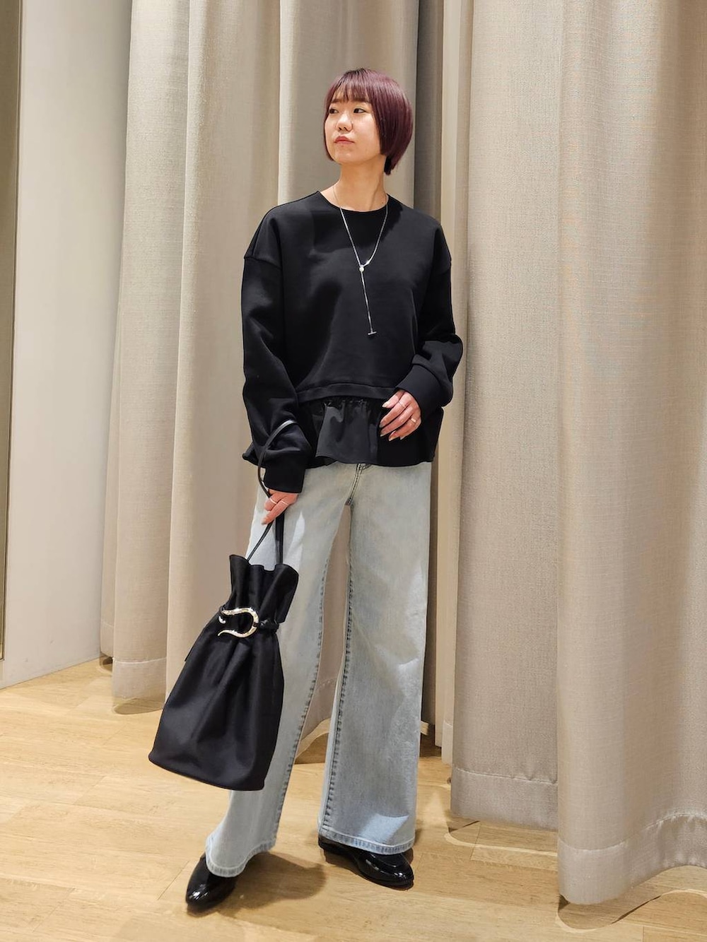 ブルー系のデニムパンツ、ブラック系のTシャツ/カットソー、ブラック系のトートバッグを着用したレディースの冬コーディネートの6枚目の写真