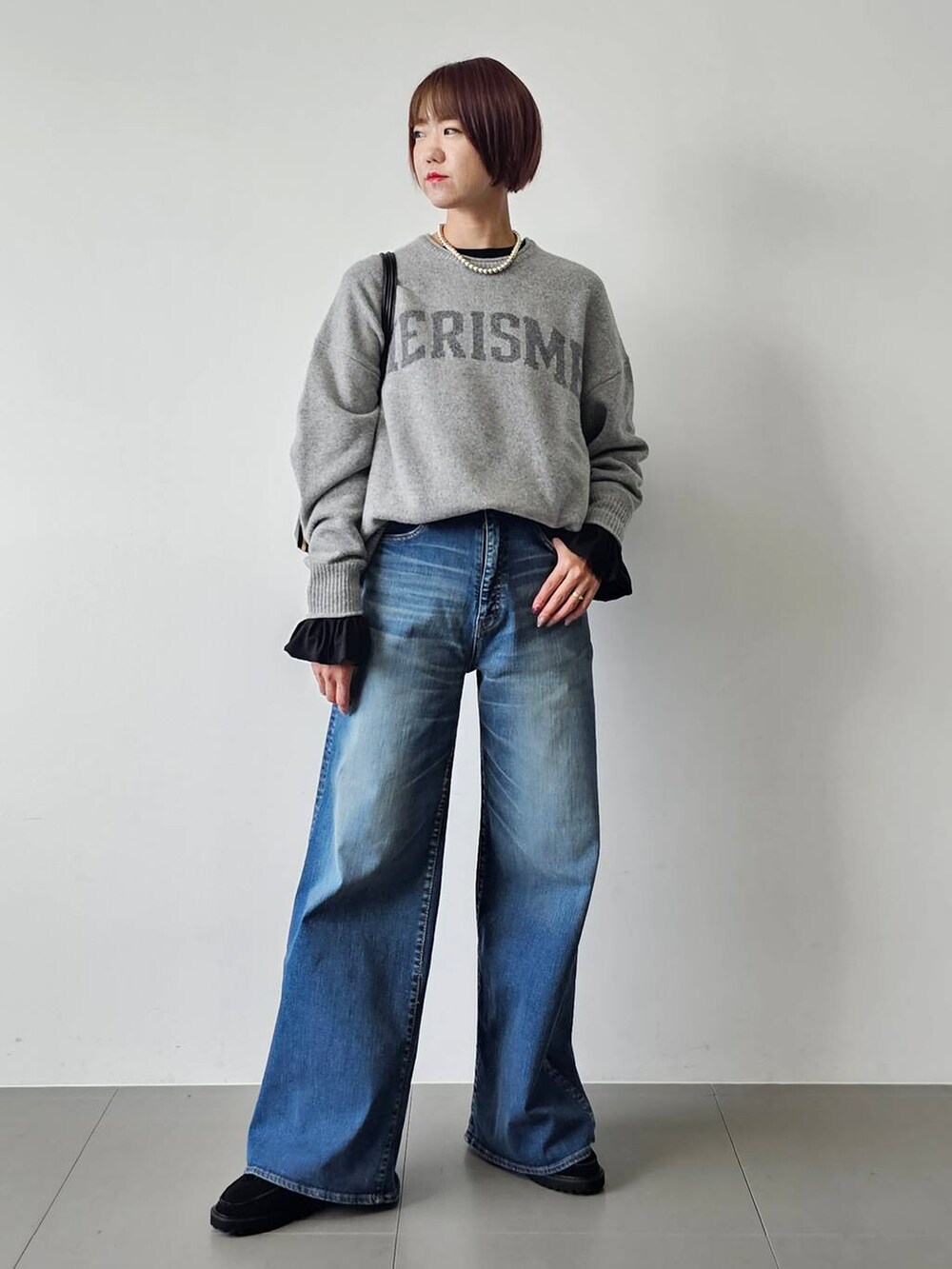 ブラック系のトートバッグ、ブラック系のTシャツ/カットソー、ブラック系のダウンジャケット/コートを着用したレディースの秋コーディネートの4枚目の写真