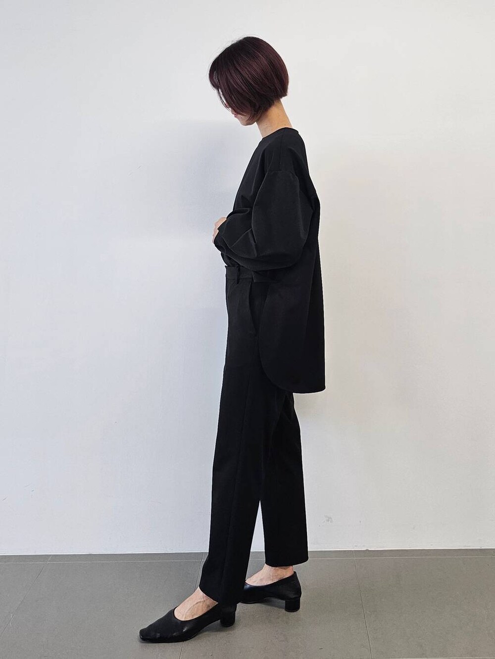 シルバー系のショルダーバッグ、ブラック系のシャツ/ブラウス、ブラック系のパンプスを着用したレディースの冬コーディネートの6枚目の写真