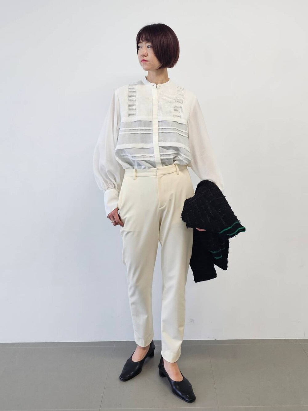 ベージュ系のボストンバッグ、ブラック系のパンプス、ホワイト系のその他パンツを着用したレディースの冬コーディネートの5枚目の写真