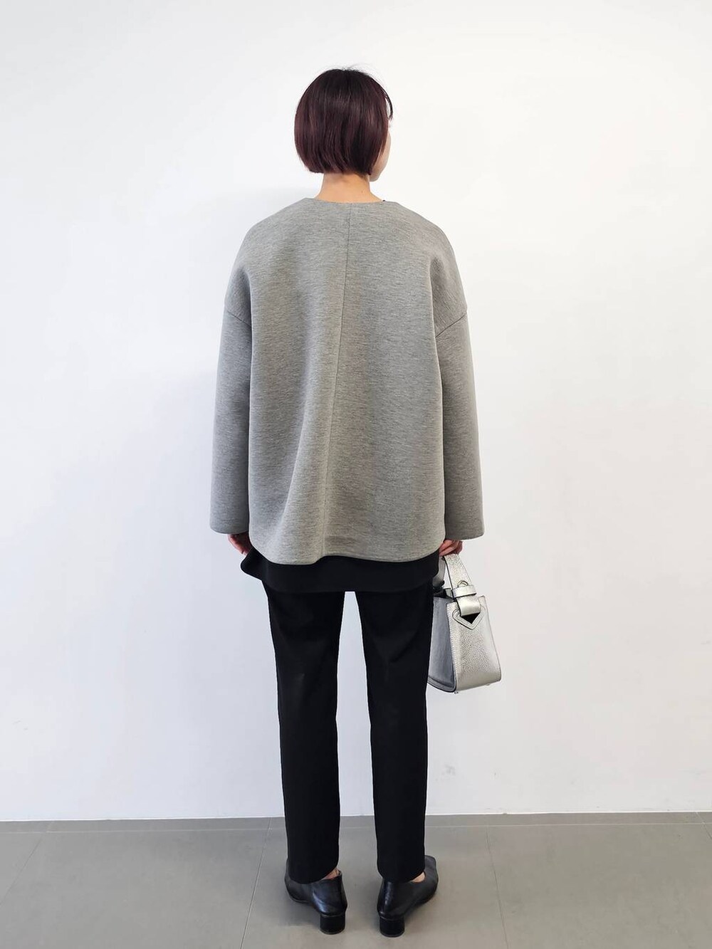 シルバー系のショルダーバッグ、ブラック系のシャツ/ブラウス、ブラック系のパンプスを着用したレディースの冬コーディネートの2枚目の写真