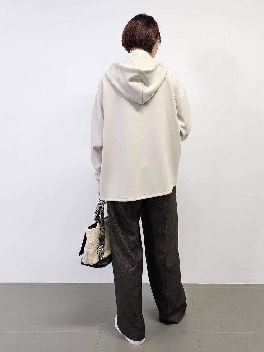 ホワイト系のTシャツ/カットソー、ホワイト系のスニーカー、ホワイト系のトートバッグを着用したレディースの冬コーディネートの3枚目の写真