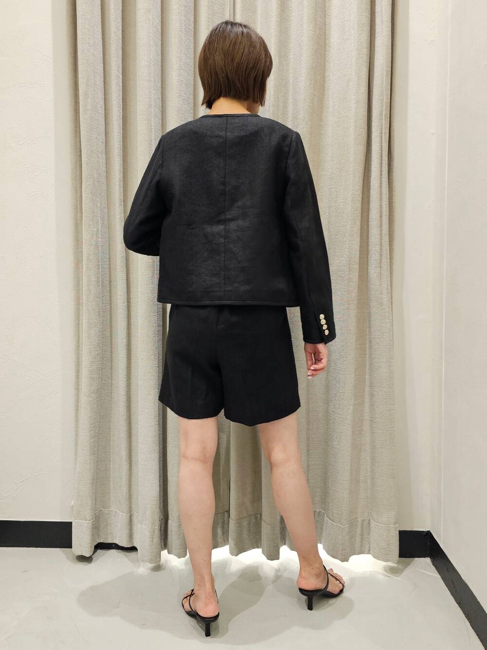 ブラック系のスリッポン、ブラック系のノーカラージャケット、ブラック系のその他パンツを着用したレディースの夏コーディネートの4枚目の写真