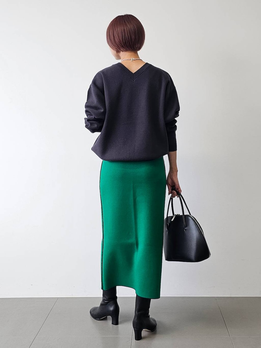 ブラック系のトートバッグ、ブラック系のブーツ、ブルー系のニット/セーターを着用したレディースの秋コーディネートの3枚目の写真