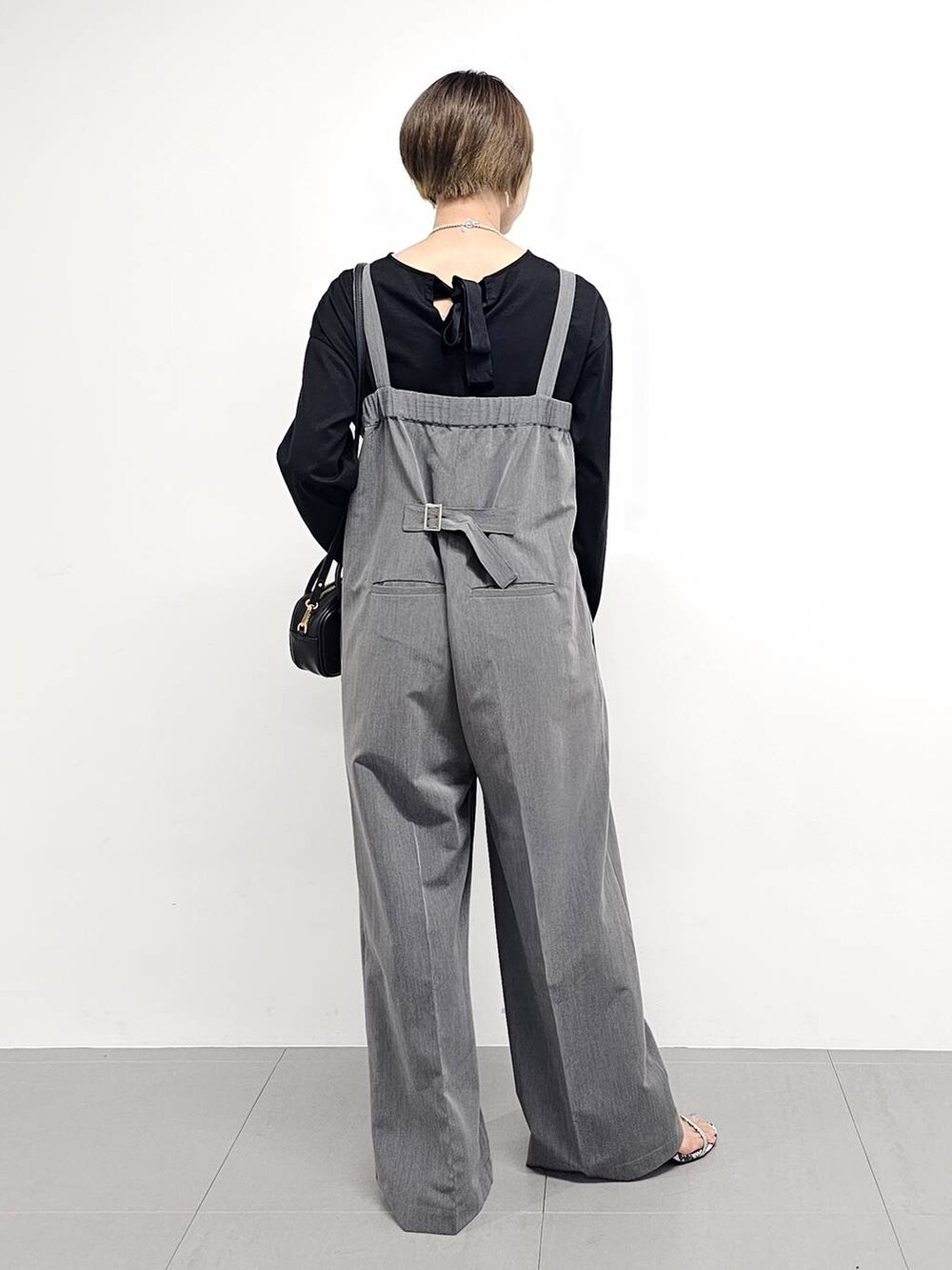 グレー系のサロペット/オーバーオール、その他のサンダル、ブラック系のTシャツ/カットソーを着用したレディースの秋コーディネートの6枚目の写真
