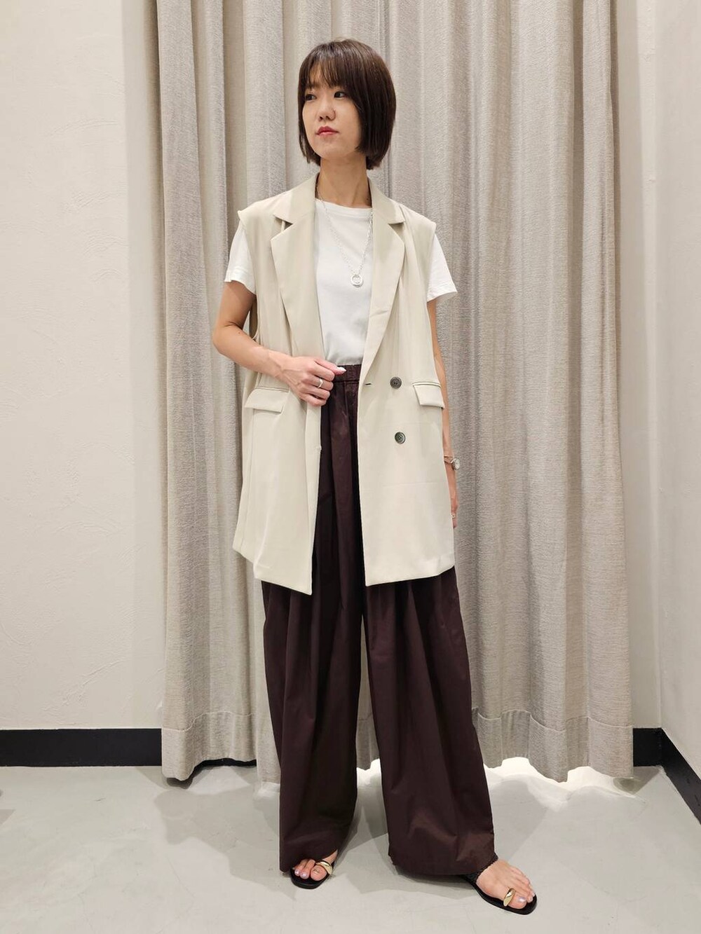 ブラウン系のその他パンツ、ホワイト系のTシャツ/カットソー、ブラック系のサンダルを着用したレディースの夏コーディネートの6枚目の写真