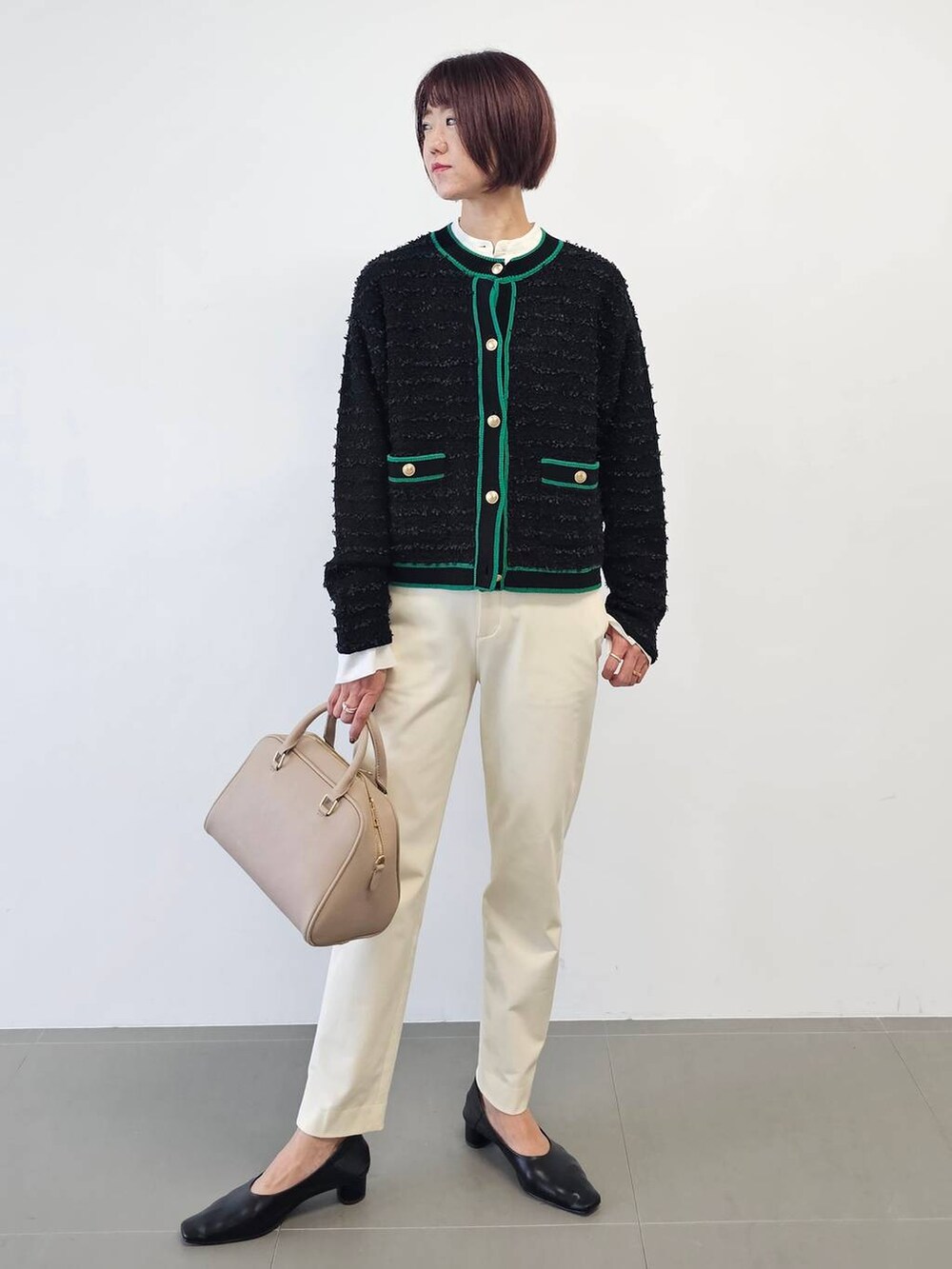 ベージュ系のボストンバッグ、ブラック系のパンプス、ホワイト系のその他パンツを着用したレディースの冬コーディネートの2枚目の写真