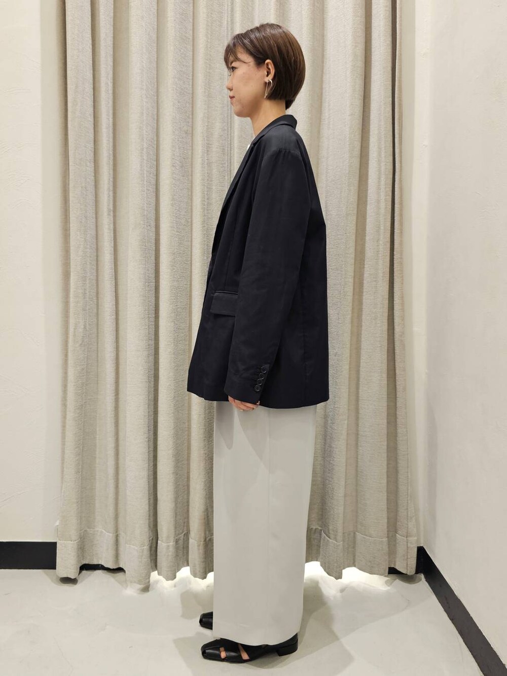 ブラック系のパンプス、ホワイト系のTシャツ/カットソー、グレー系のスラックスを着用したレディースの秋コーディネートの3枚目の写真