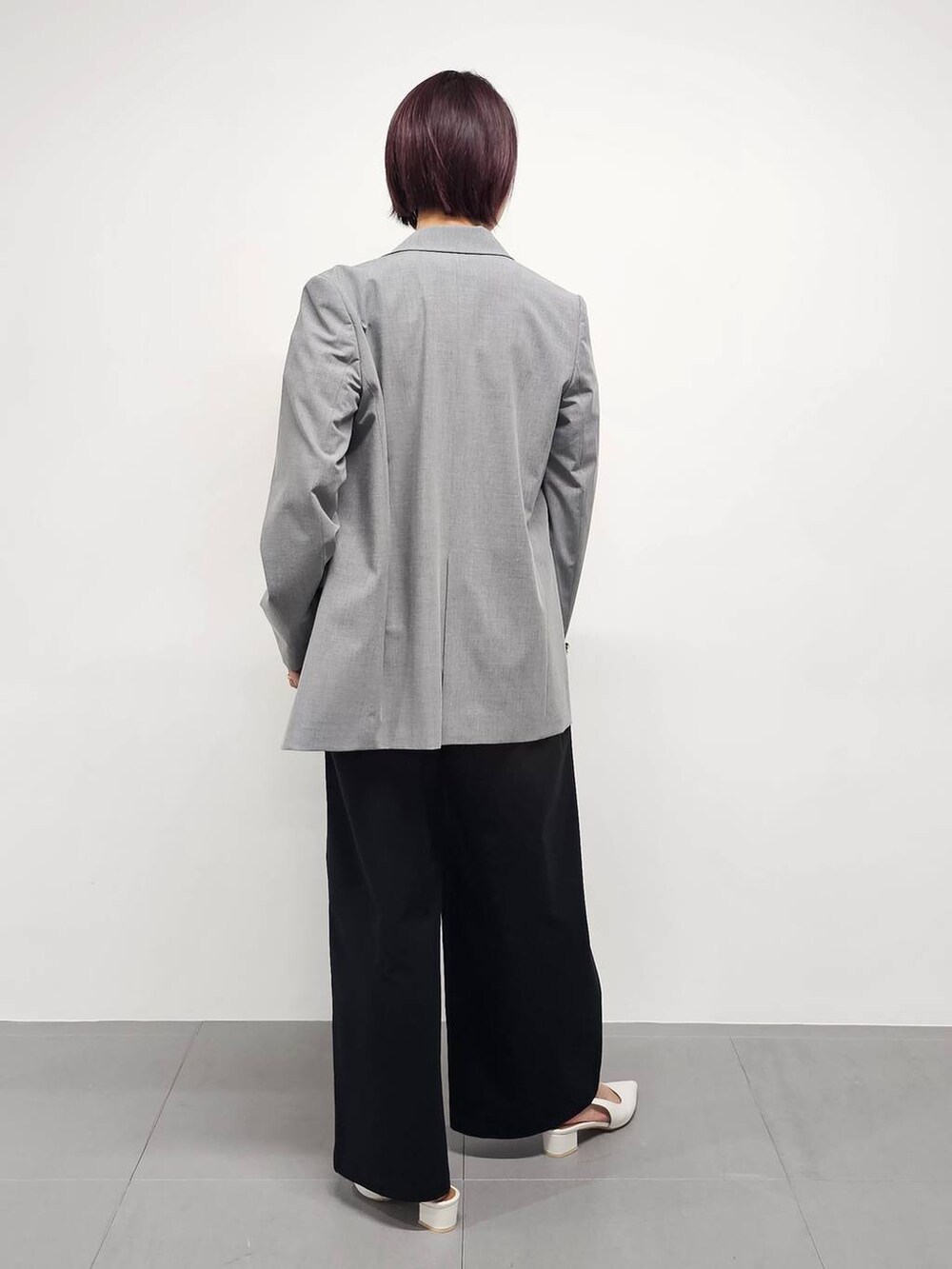 ブラック系のつなぎ/オールインワン、グレー系のテーラードジャケット、ホワイト系のパンプスを着用したレディースの冬コーディネートの3枚目の写真
