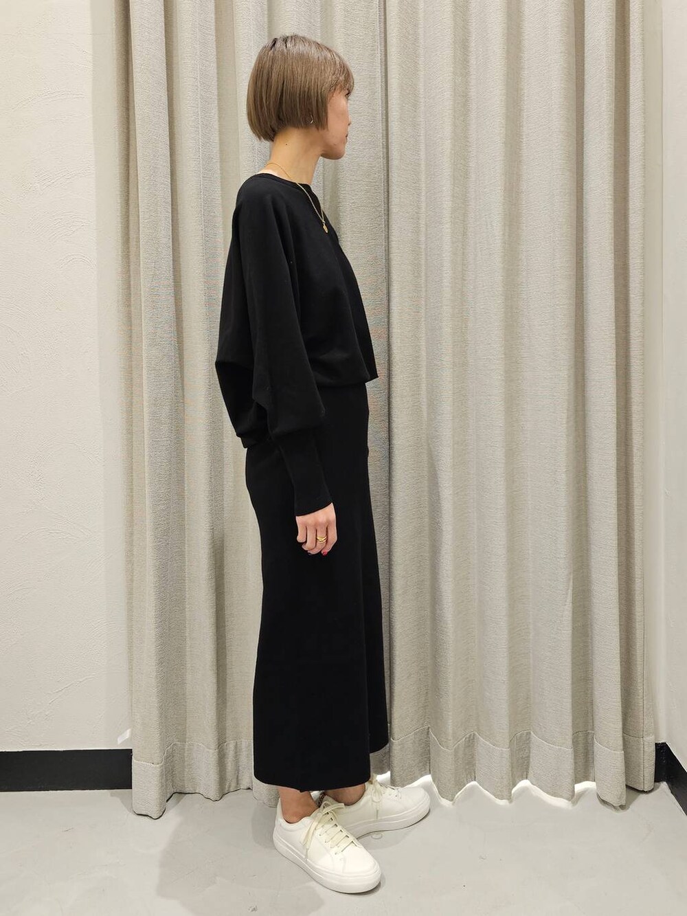 ブラック系のTシャツ/カットソー、ブラック系のスカート、ホワイト系のスニーカーを着用したレディースの冬コーディネートの5枚目の写真