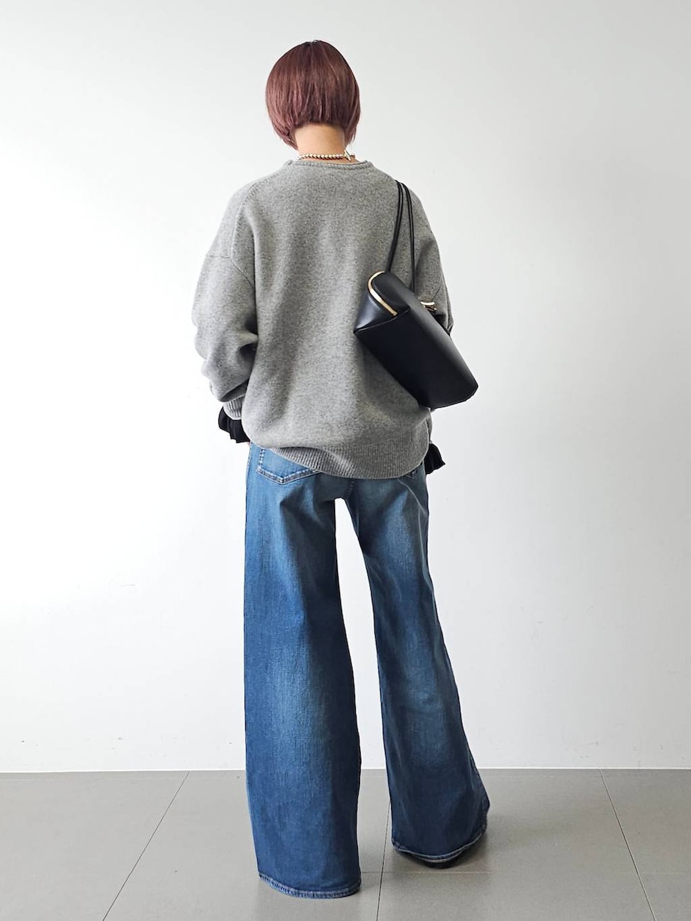 ブラック系のトートバッグ、ブラック系のTシャツ/カットソー、ブラック系のダウンジャケット/コートを着用したレディースの秋コーディネートの6枚目の写真