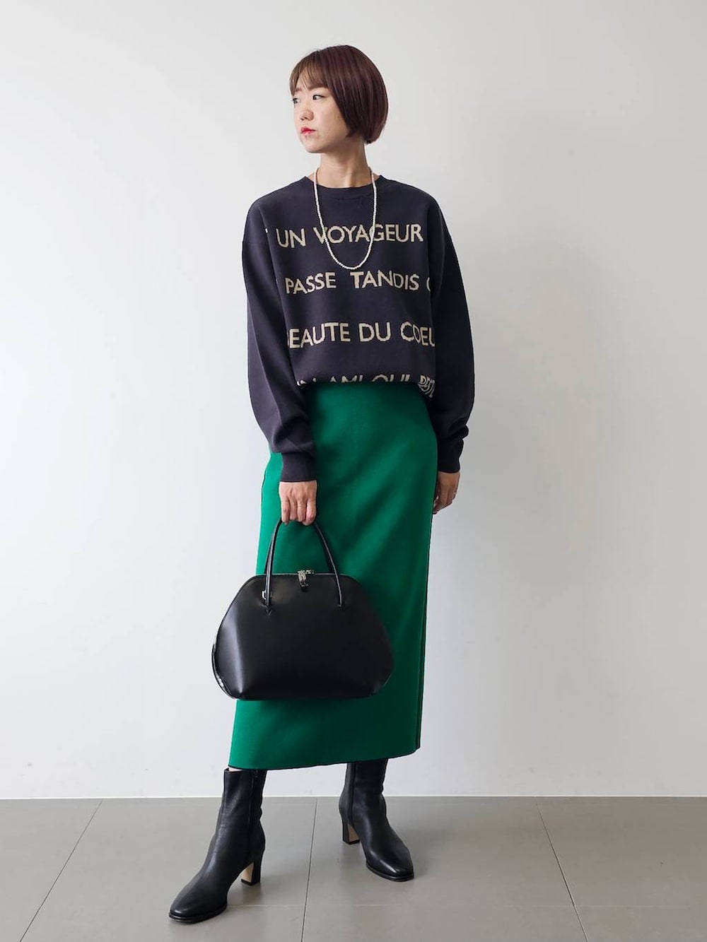 ブラック系のトートバッグ、ブラック系のブーツ、ブルー系のニット/セーターを着用したレディースの秋コーディネートの4枚目の写真