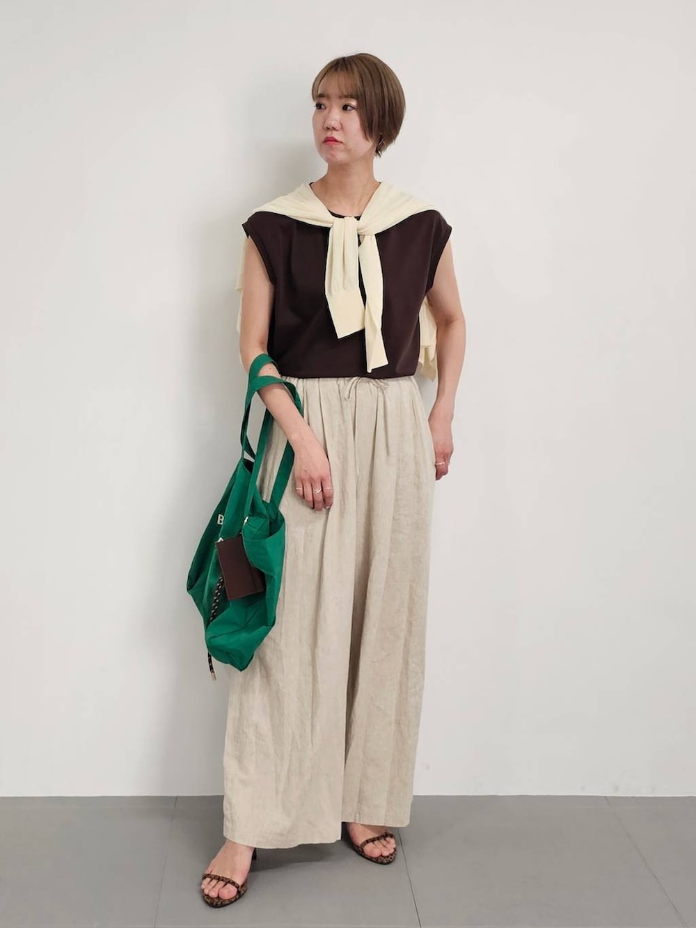 ホワイト系のカーディガン/ボレロ、ベージュ系のその他パンツ、ブラウン系のTシャツ/カットソーを着用したレディースの春コーディネートの3枚目の写真