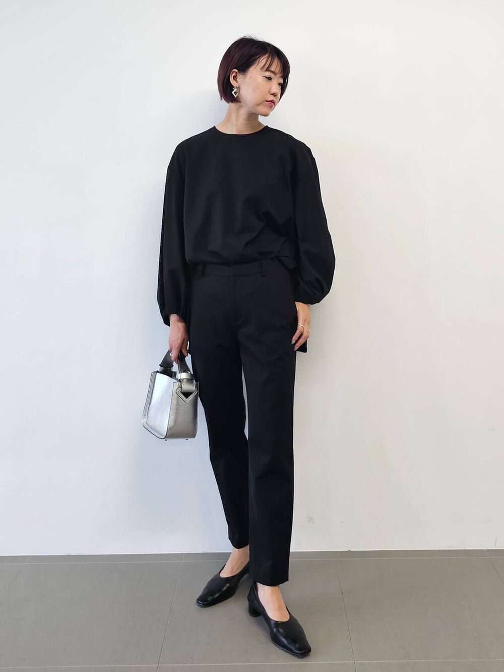 シルバー系のショルダーバッグ、ブラック系のシャツ/ブラウス、ブラック系のパンプスを着用したレディースの冬コーディネートの8枚目の写真