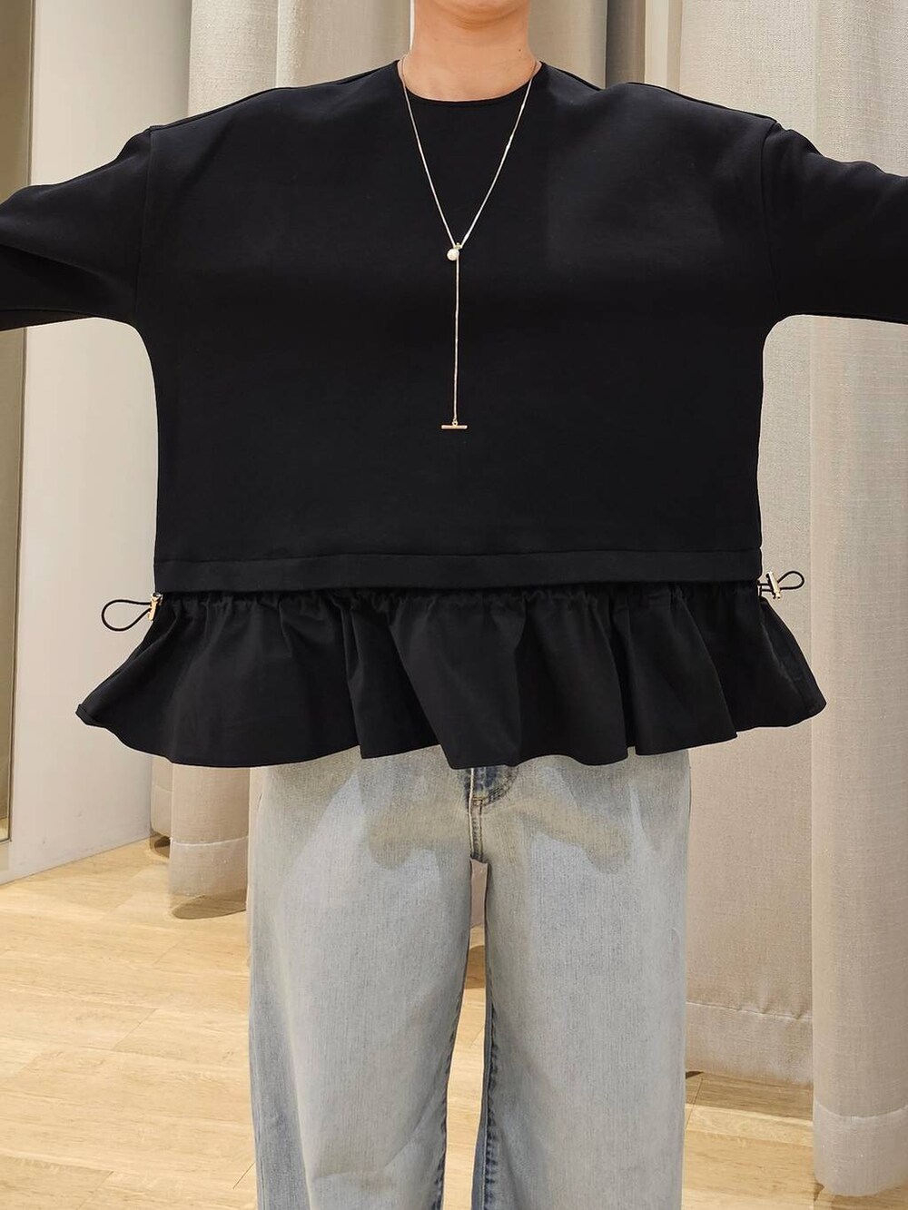 ブルー系のデニムパンツ、ブラック系のTシャツ/カットソー、ブラック系のトートバッグを着用したレディースの冬コーディネートの3枚目の写真