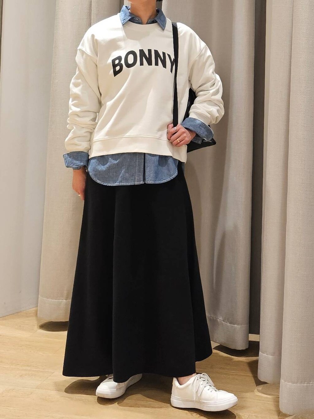 ブラック系のバックパック/リュック、ブラック系のスカート、ホワイト系のスウェットを着用したレディースの冬コーディネートの2枚目の写真