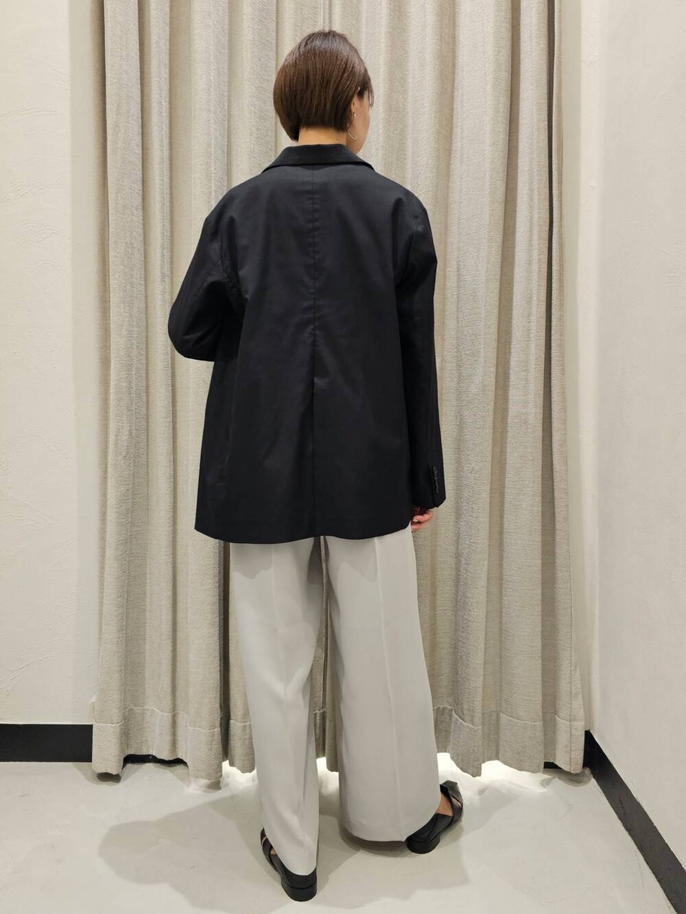 ブラック系のパンプス、ホワイト系のTシャツ/カットソー、グレー系のスラックスを着用したレディースの秋コーディネートの4枚目の写真