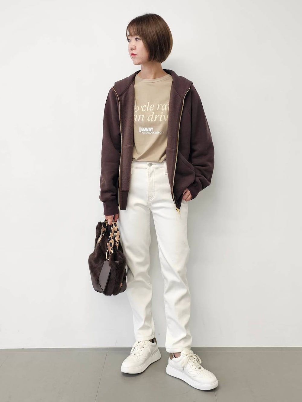 ホワイト系のデニムパンツ、ベージュ系のTシャツ/カットソー、ホワイト系のスニーカーを着用したレディースの秋コーディネートの4枚目の写真