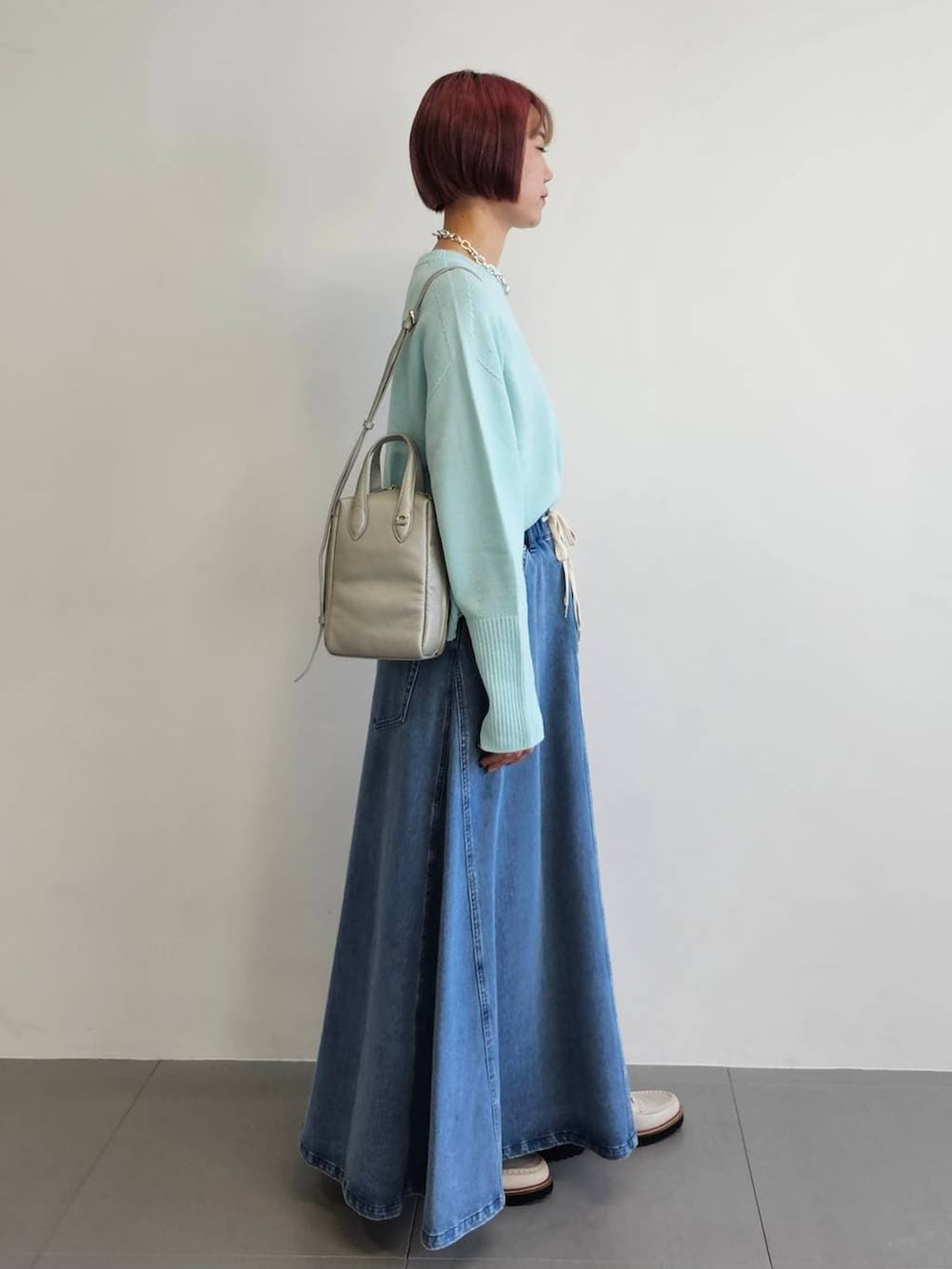 ベージュ系のローファー、ブルー系のニット/セーター、ブルー系のスカートを着用したレディースの冬コーディネートの3枚目の写真