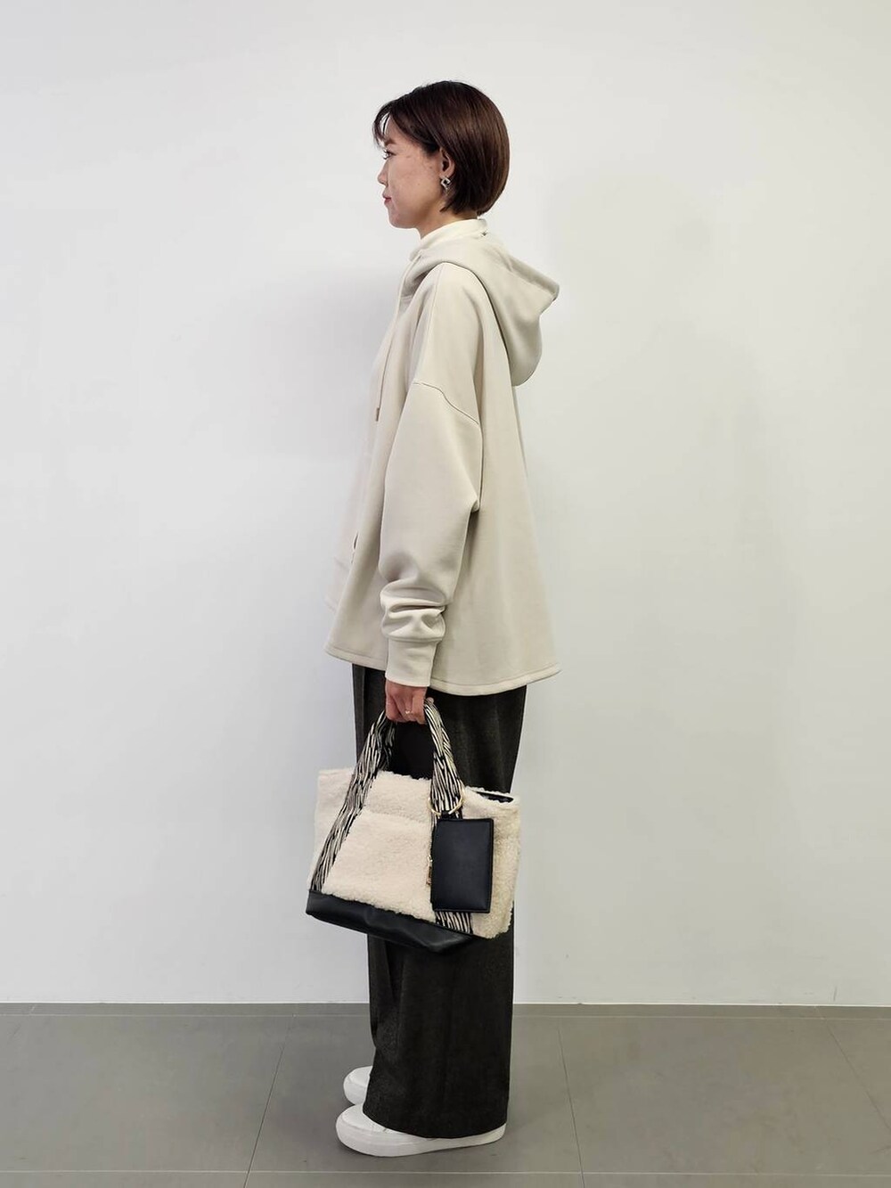 ホワイト系のTシャツ/カットソー、ホワイト系のスニーカー、ホワイト系のトートバッグを着用したレディースの冬コーディネートの4枚目の写真