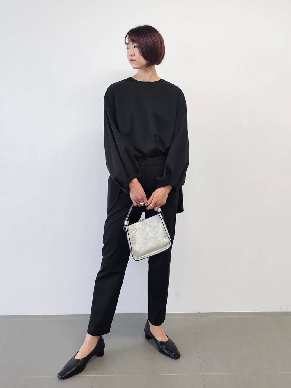 シルバー系のショルダーバッグ、ブラック系のシャツ/ブラウス、ブラック系のパンプスを着用したレディースの冬コーディネートの5枚目の写真