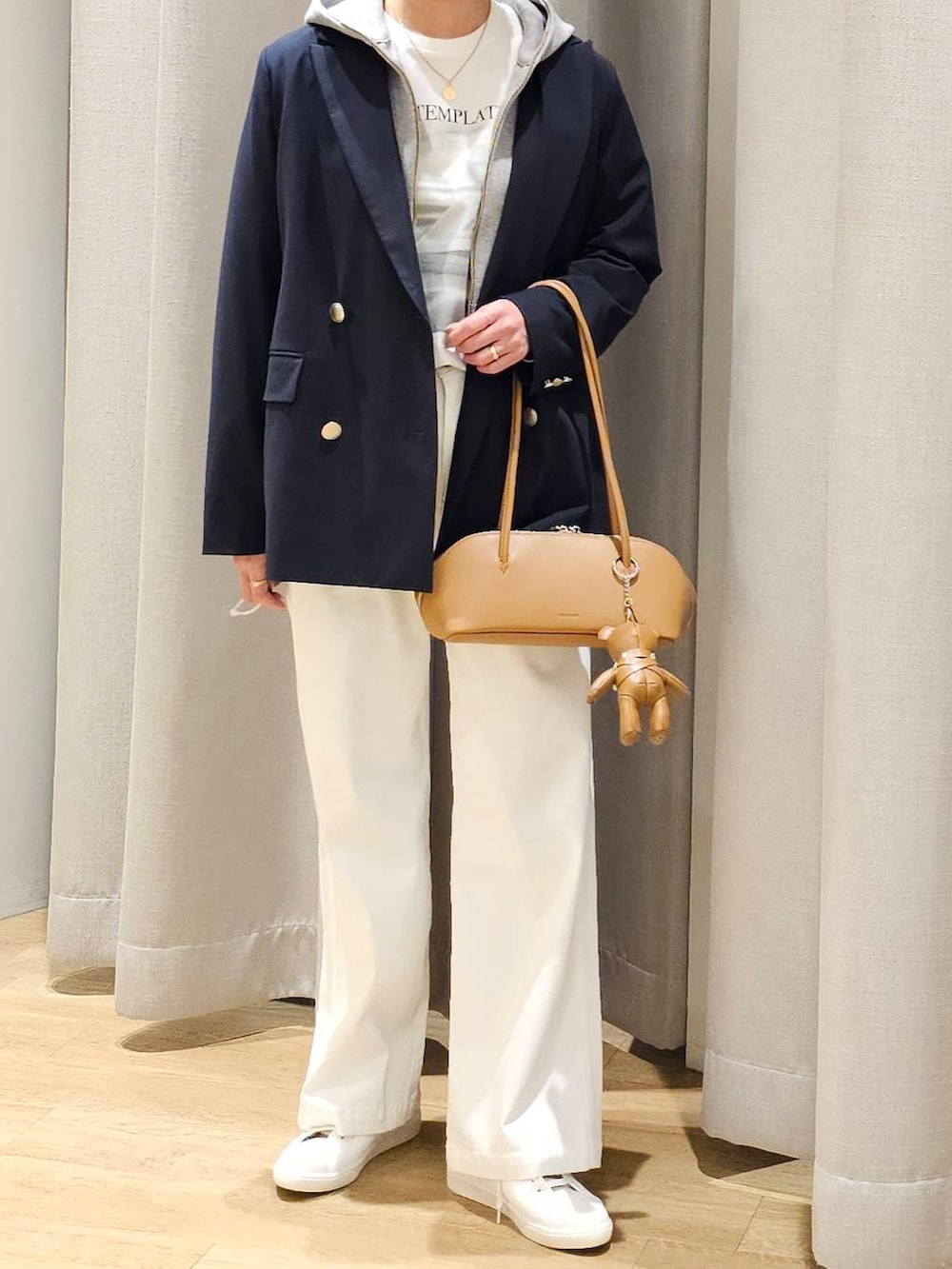 グレー系のパーカー、ホワイト系のTシャツ/カットソー、ブルー系のテーラードジャケットを着用したレディースの冬コーディネートの2枚目の写真