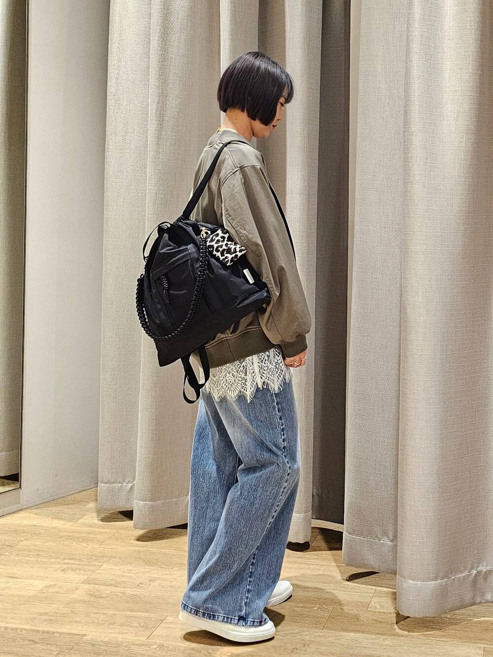 ブルー系のデニムパンツ、グレー系のスウェット、グリーン系のMA-1を着用したレディースの冬コーディネートの2枚目の写真