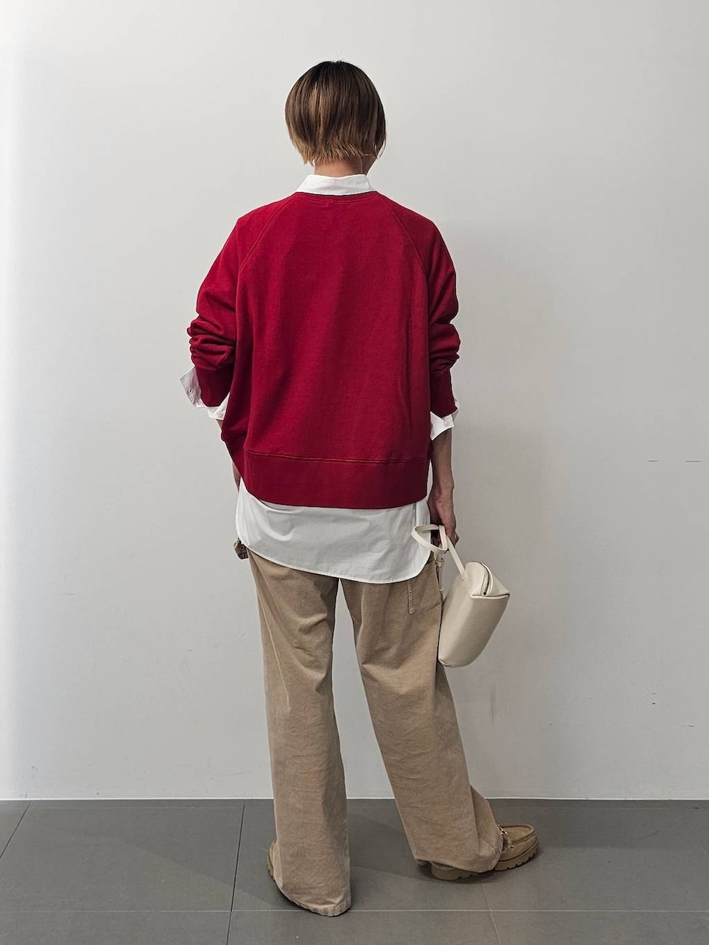 ホワイト系のショルダーバッグ、ホワイト系のシャツ/ブラウス、ベージュ系のチノパンツを着用したレディースの秋コーディネートの4枚目の写真