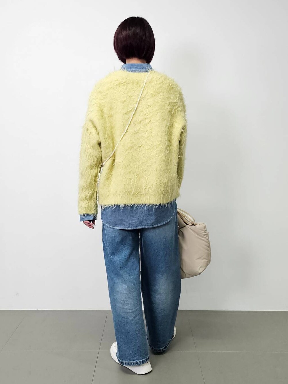 ブルー系のデニムパンツ、ブルー系のシャツ/ブラウス、イエロー系のカーディガン/ボレロを着用したレディースの秋コーディネートの3枚目の写真