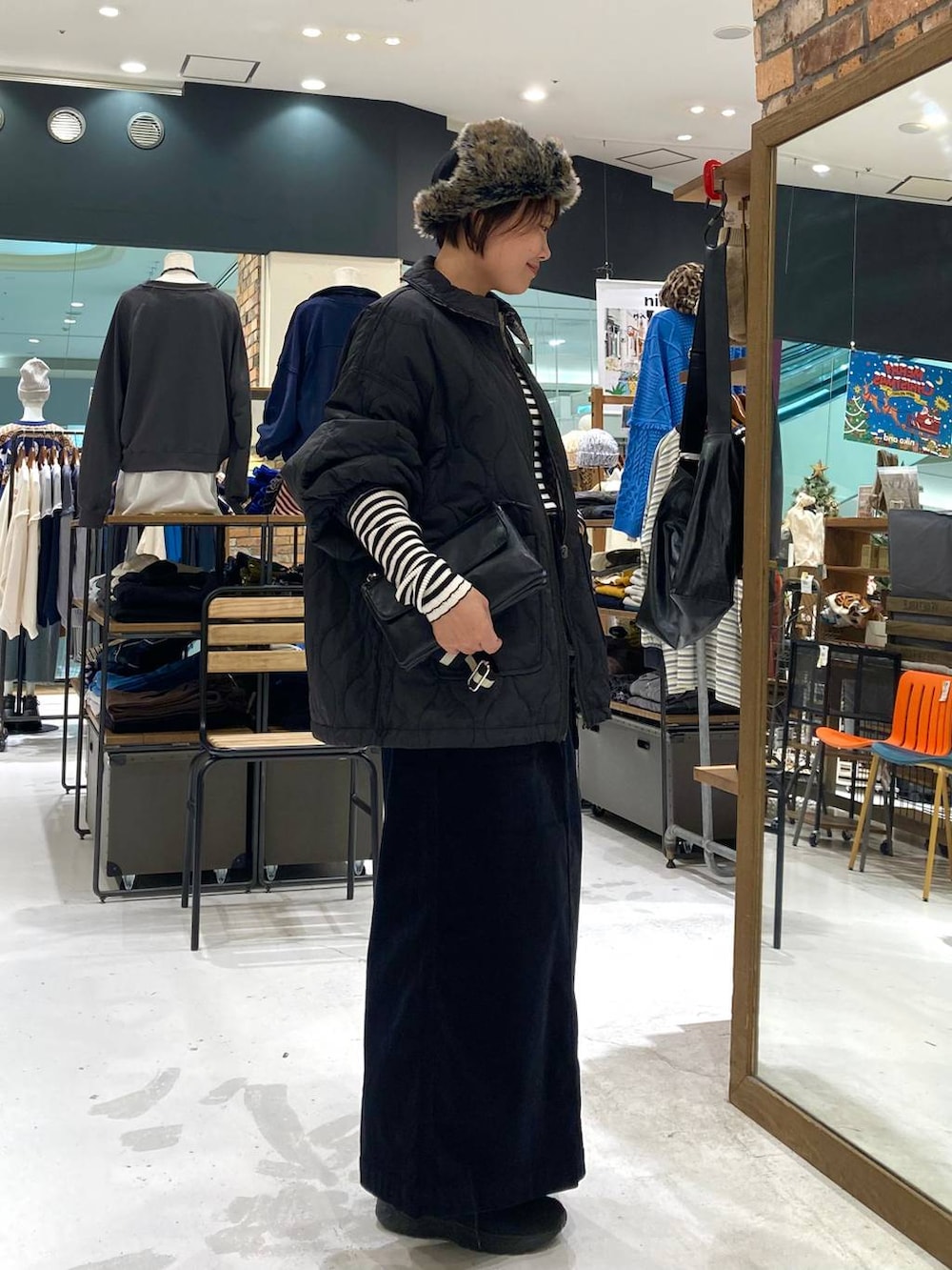 ブラック系のその他アウター、ホワイト系のニット/セーター、ブラック系のショルダーバッグを着用したレディースの冬コーディネートの5枚目の写真