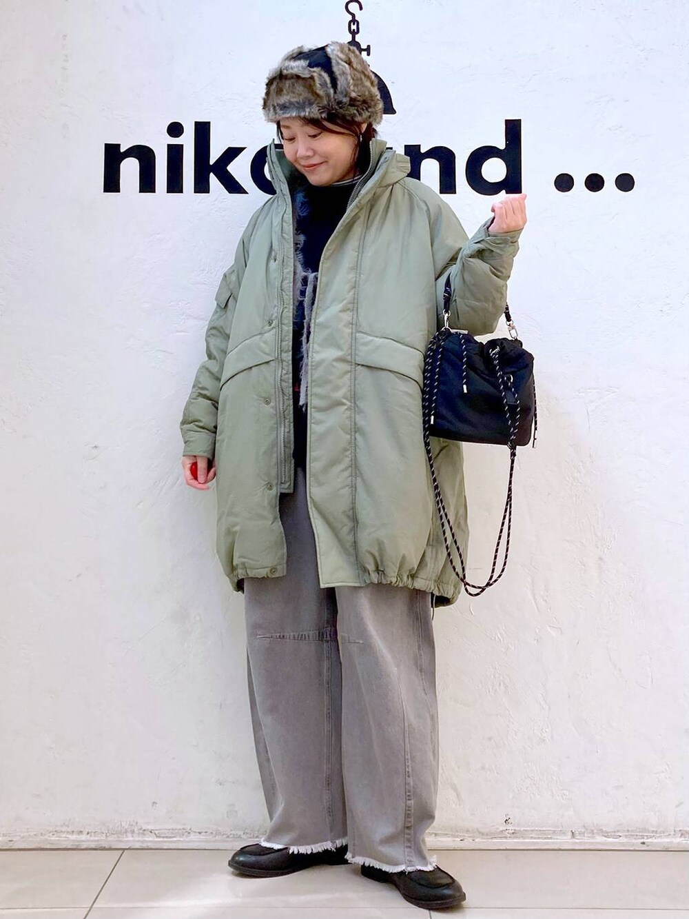 グリーン系のブルゾン、ホワイト系のTシャツ/カットソー、グレー系のその他パンツを着用したレディースの冬コーディネートの3枚目の写真
