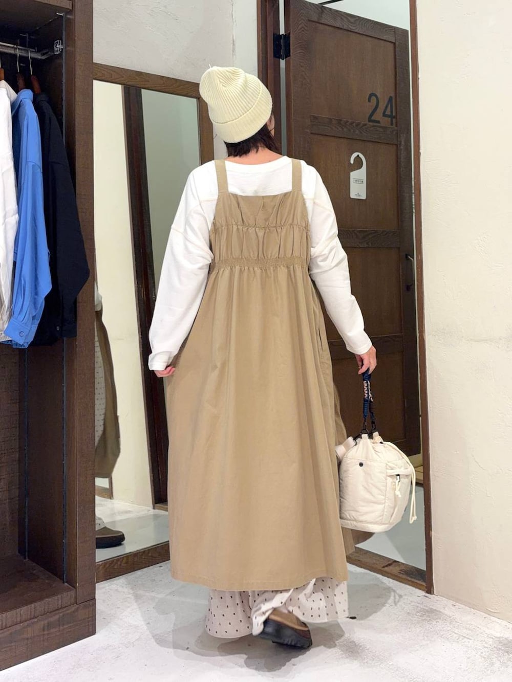 ベージュ系のジャンパースカート、ベージュ系のその他シューズ、ホワイト系のTシャツ/カットソーを着用したレディースの冬コーディネートの3枚目の写真