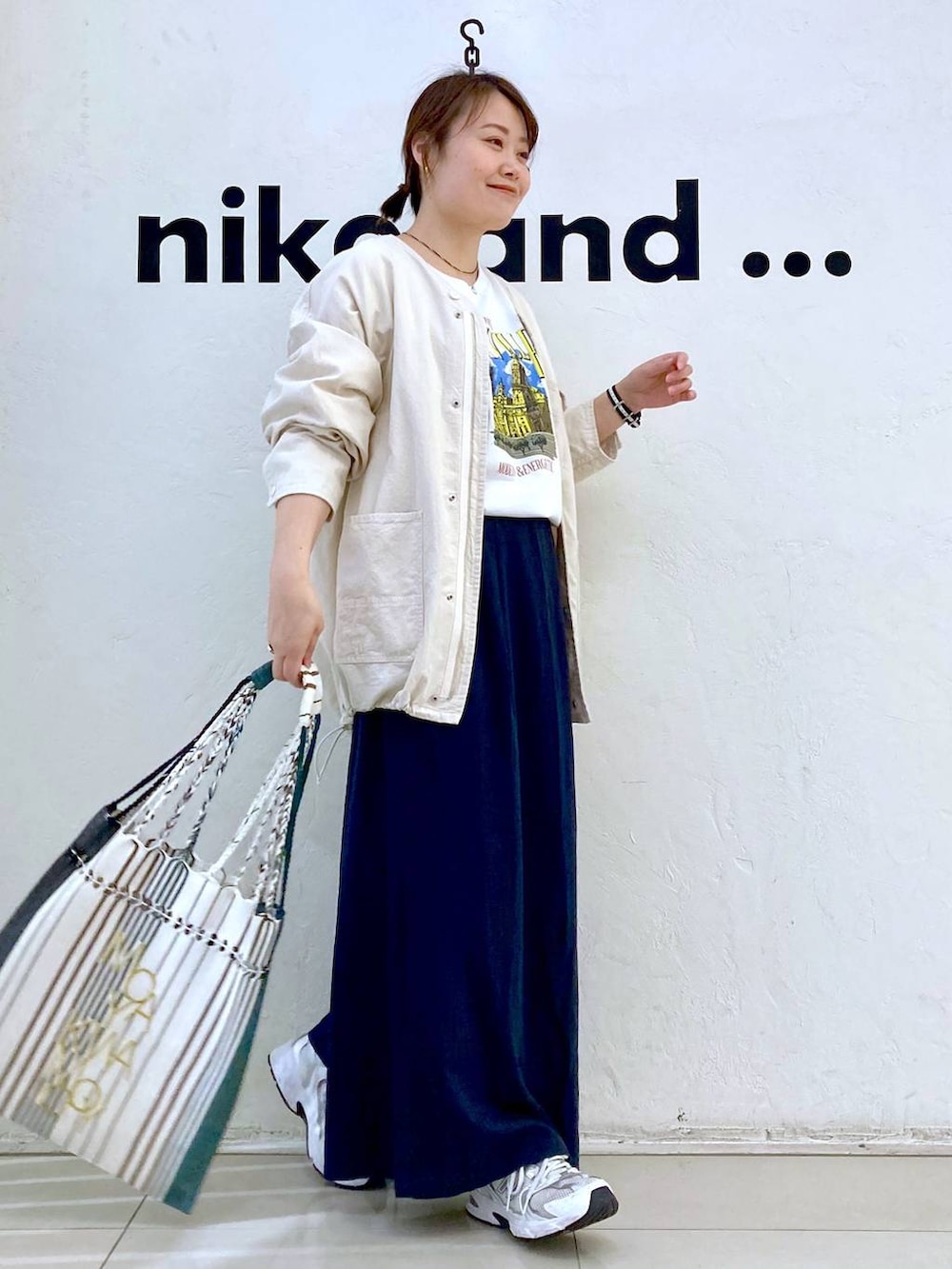 ホワイト系のTシャツ/カットソー、ブラック系のトートバッグ、ベージュ系のブルゾンを着用したレディースの春コーディネートの4枚目の写真