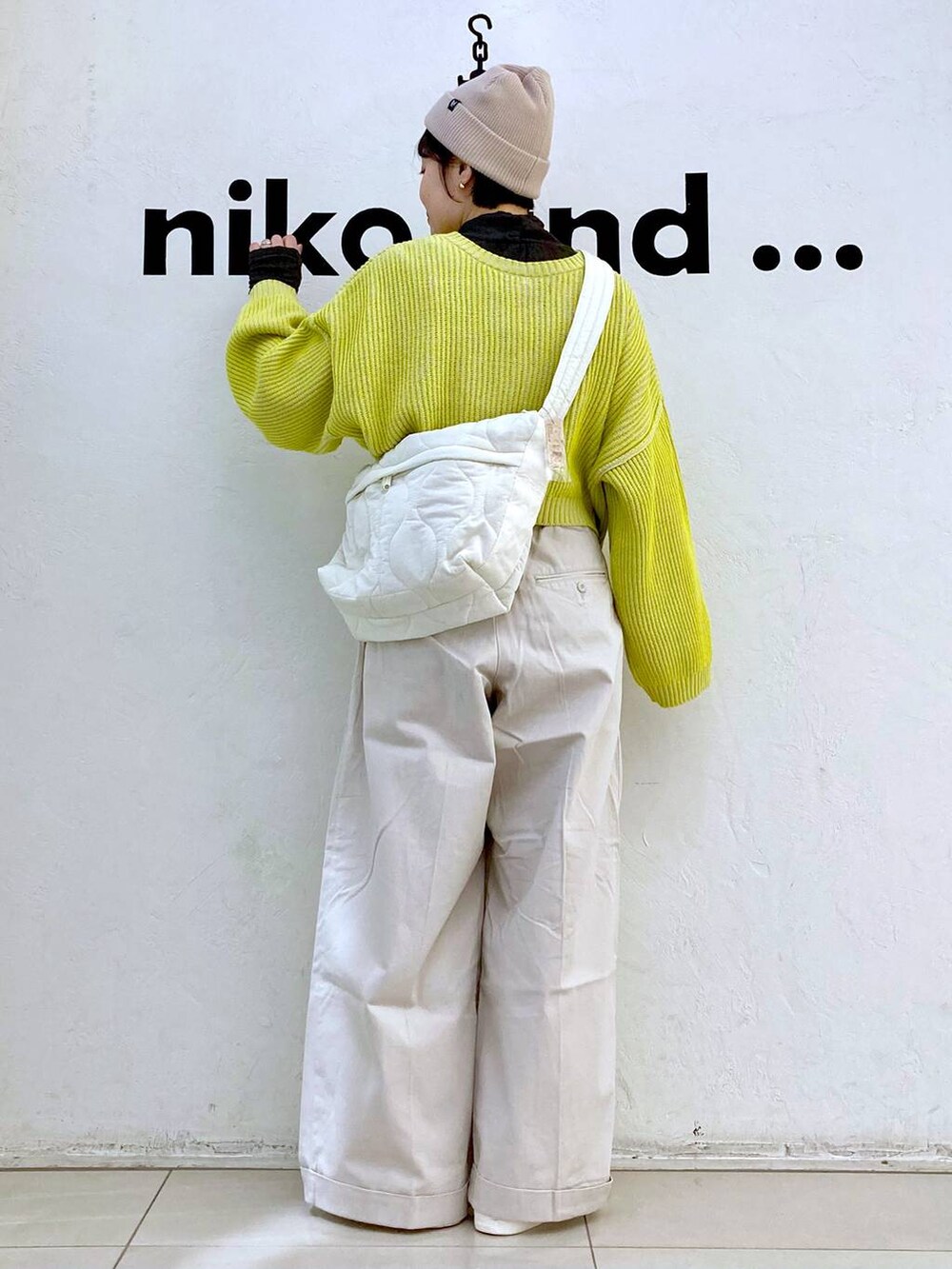 ベージュ系のその他パンツ、イエロー系のニット/セーター、ホワイト系のスニーカーを着用したレディースの冬コーディネートの4枚目の写真