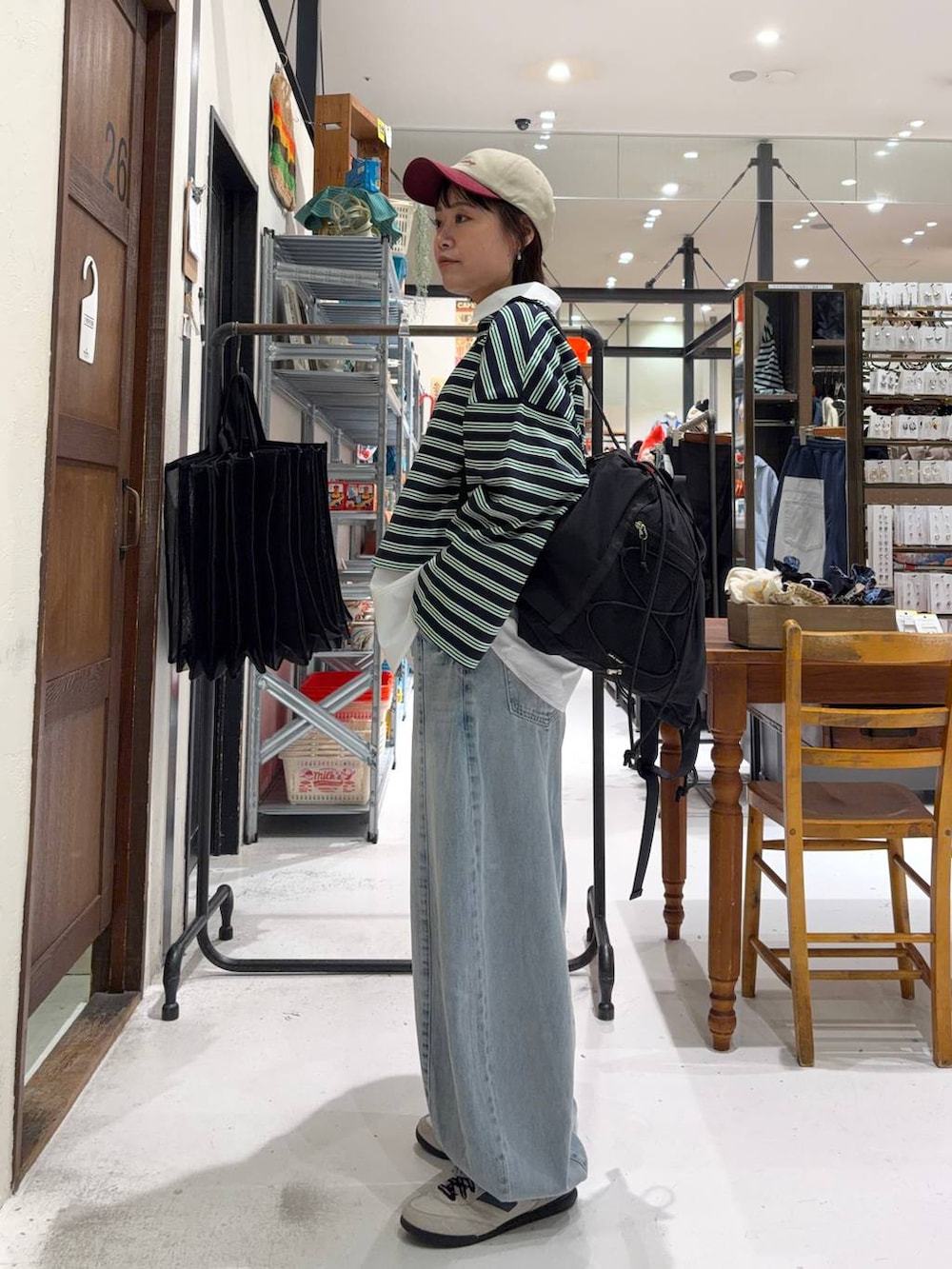 ブラック系のバックパック/リュック、ホワイト系のシャツ/ブラウス、ブルー系のデニムパンツを着用したレディースの冬コーディネートの3枚目の写真