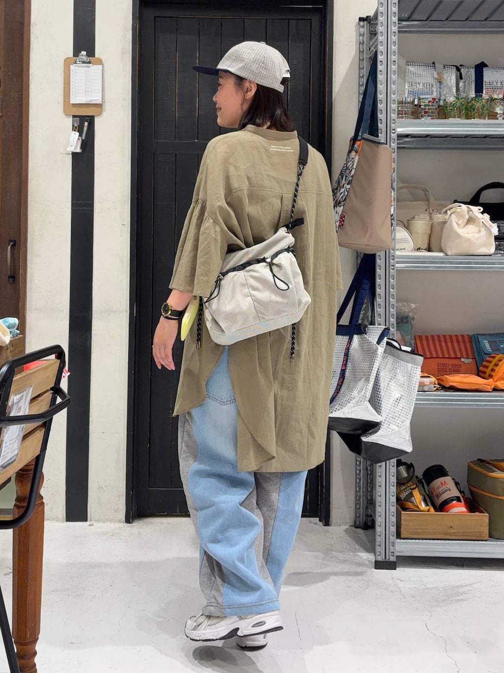 グレー系のデニムパンツ、ベージュ系のショルダーバッグを着用したレディースの夏コーディネートの4枚目の写真