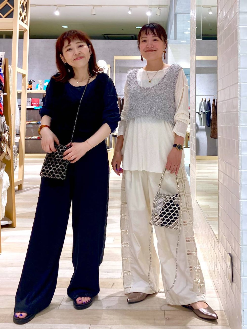 シルバー系のショルダーバッグ、ベージュ系のその他パンツ、ブラック系のその他パンツを着用したレディースの夏コーディネートの2枚目の写真